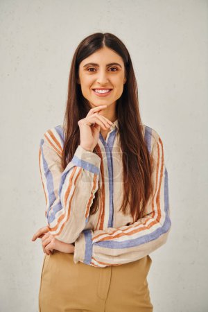 Photo for Stylish woman in striped shirt and tan pants posing for a portrait. - Royalty Free Image