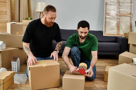 Two men sit on the floor surrounded by moving boxes, embracing the start of a new life in their new home.
