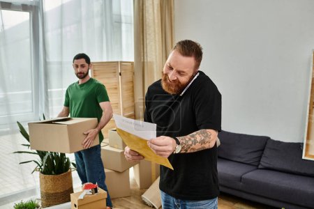 A man excitedly holds a paper in a cozy living room filled with moving boxes, starting a new chapter in his life.