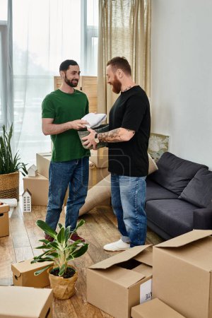 Ein verliebtes schwules Paar steht in seinem neuen Wohnzimmer, umgeben von Kisten, und umarmt die Aufregung eines Neuanfangs.