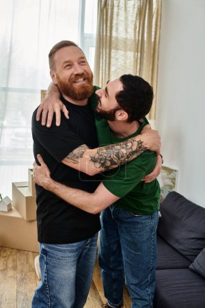 Two men embrace each other warmly in a cozy living room filled with moving boxes, starting a new chapter in their lives.