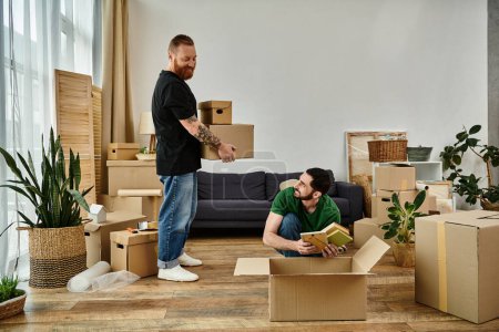 Foto de A gay couple in love, stand in a living room surrounded by moving boxes, starting a new chapter together. - Imagen libre de derechos