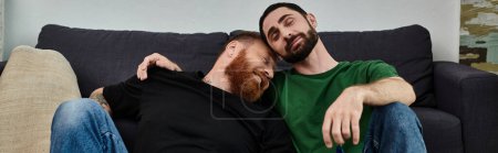 Téléchargez les photos : Couple d'hommes refroidissant sur le canapé élégant, embrassant un nouveau chapitre dans un cadre confortable. - en image libre de droit