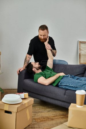 couple gay relaxant sur un canapé, incarnant un moment paisible et aimant dans leur nouvelle maison.