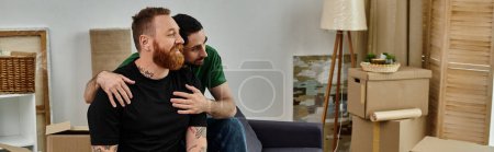 Téléchargez les photos : Deux hommes s'embrassent passionnément au milieu de boîtes mobiles dans un nouveau salon, incarnant l'amour et de nouveaux départs. - en image libre de droit