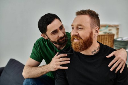 Deux hommes, un couple gay amoureux, assis sur un canapé, profitant d'un moment de calme ensemble dans leur nouvelle maison.