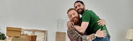 Téléchargez les photos : A man lovingly embraces another man in a room filled with moving boxes, symbolizing a new chapter in their life together. - en image libre de droit