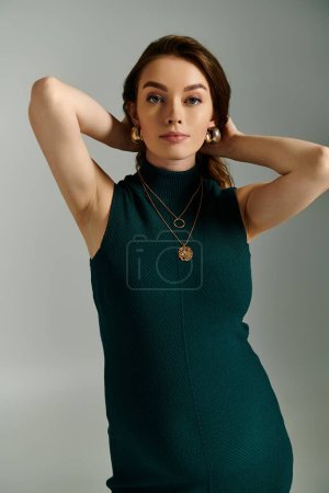 A stylish woman in a beautiful green dress posing gracefully for a portrait, exuding confidence and elegance.