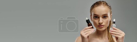 Photo for Woman holding two hair bottles in front of her face. - Royalty Free Image