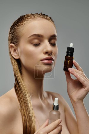 Photo for Young woman demonstrates hair care routine with wet hair, holding oil and lotion bottles. - Royalty Free Image