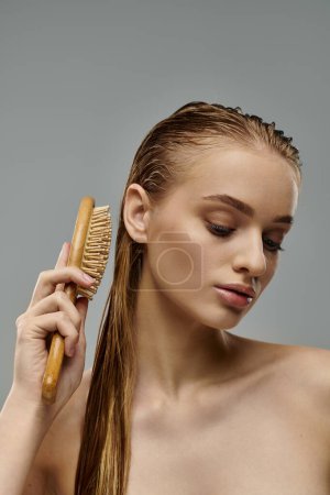 A young woman with wet hair showcases her hair care routine by brushing her long locks.