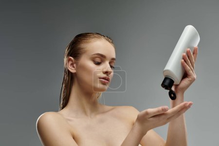 Téléchargez les photos : Appealing woman sensually holds a bottle of hair treatment. - en image libre de droit