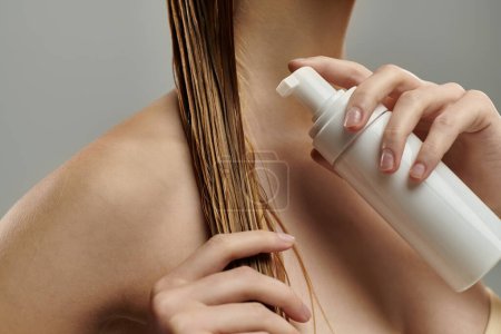 Téléchargez les photos : Young woman applying hair treatment. - en image libre de droit