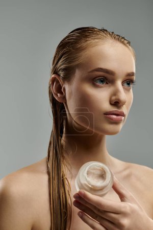 Stylish woman with ponytail showcasing care with cream jar.