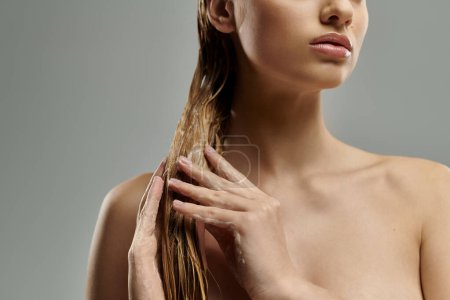 Téléchargez les photos : Femme aux cheveux longs appliquant tendrement des produits de soins capillaires. - en image libre de droit