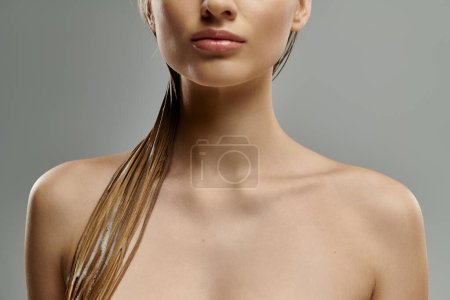 Eine junge Frau mit außergewöhnlich langen Haaren posiert anmutig und präsentiert ihre Haarpflege-Routine mit nassen Haaren.