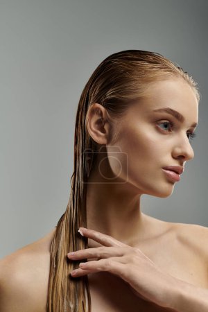 Mujer bonita con cabello largo aplicando tiernamente productos para el cuidado del cabello.