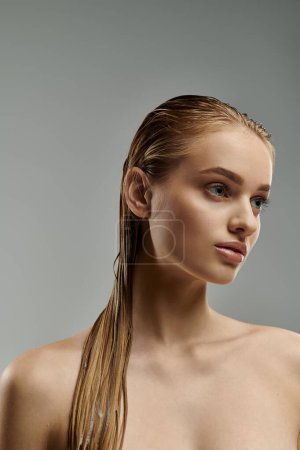 Junge Schönheit demonstriert Haarpflege mit langen, nassen Haaren.