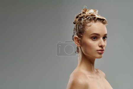 Mujer joven demuestra rutina de cuidado del cabello con cabello mojado.