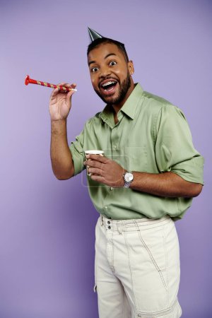 A young African American man in braces joyfully holds a straw while wearing a party hat against a vibrant purple background.