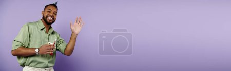 Téléchargez les photos : Jeune homme avec bretelles se dresse avec confiance contre un mur violet vibrant, exsudant joie et positivité. - en image libre de droit