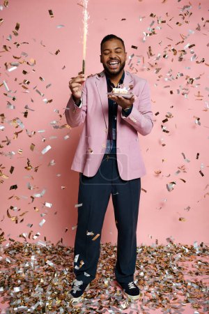 Cheerful African American man in pink jacket and braces holding sparkler against vibrant pink background.