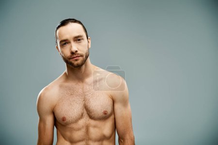 Photo for A bearded, shirtless man exudes confidence against a grey backdrop. - Royalty Free Image