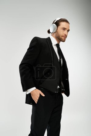 A bearded businessman in a suit wears headphones, lost in the music playing in his ears.