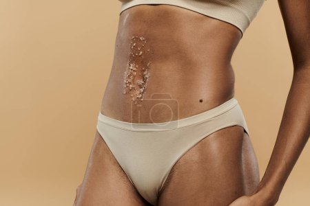 An exquisite piece of skin placed on the stomach of a slim African American woman in underwear.