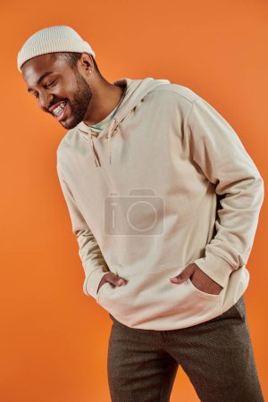 Photo for Stylish African American man with hands in pockets against vibrant backdrop. - Royalty Free Image