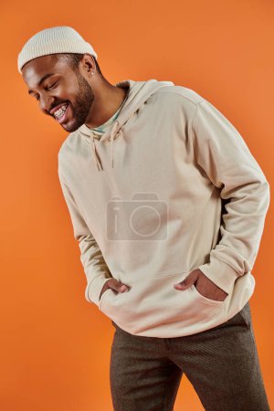Stylish African American man with hands in pockets against vibrant backdrop.