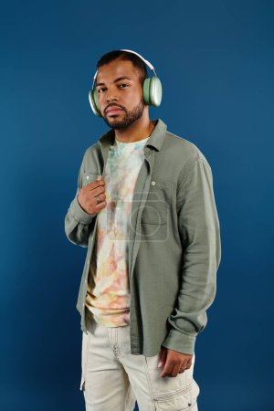 Téléchargez les photos : Un Afro-Américain avec des écouteurs sur fond bleu vif. - en image libre de droit