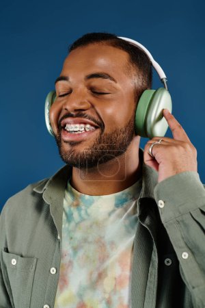 Photo for Stylish African American man smiling, wearing headphones. - Royalty Free Image