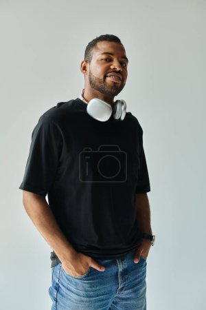 Stylish African American man enjoys music with headphones on.