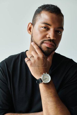Afroamerikaner präsentiert Armbanduhr auf buntem Hintergrund.