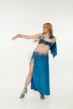 A captivating young woman in a vibrant blue belly dance outfit.