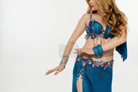 Mujer joven hipnotiza en un traje de danza del vientre azul.