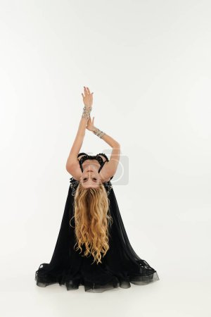 Frau im schwarzen Kleid macht mühelos Handstand