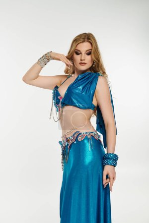 Eine bezaubernde junge Frau zeigt ihr Können in einem lebendigen blauen Bauchtanz-Outfit.