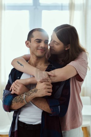 Foto de Lgbt pareja en ropa casual abrazándose en un momento íntimo en casa. - Imagen libre de derechos
