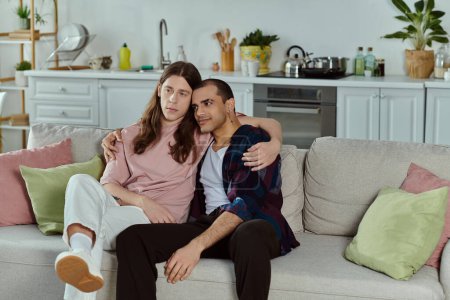 lgbtq couple enjoy a cozy moment on a couch, laughter filling the room as they relax together.