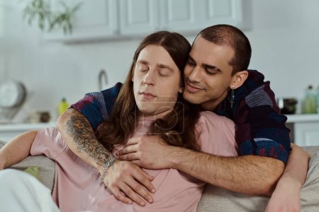 Photo for Lgbtq couple in casual clothes embrace warmly on a cozy couch in a living room. - Royalty Free Image