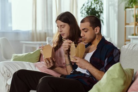 Una pareja gay en ropa casual pasando tiempo de calidad juntos, sentados en un sofá en un ambiente acogedor en casa.