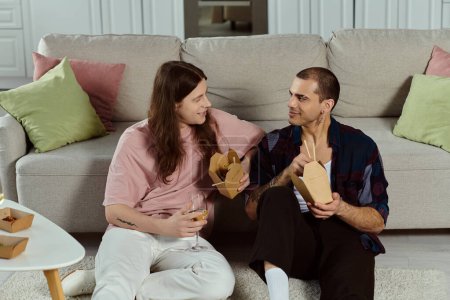 Zwei Menschen genießen einander Gesellschaft auf einer gemütlichen Couch zu Hause.