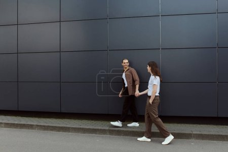Photo for A gay couple, casually dressed, enjoying a leisurely walk together on the city streets. - Royalty Free Image