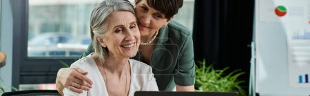 Two women engaged with laptop.
