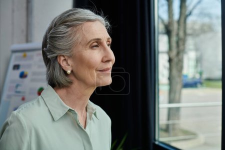 Una mujer mira por una ventana a la bulliciosa calle de abajo.