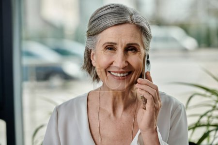 Ältere Frau unterhält sich aufmerksam mit Handy.
