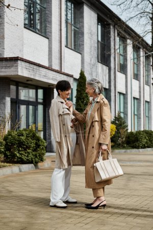 Zwei kultivierte Frauen stehen in Ehrfurcht vor einem großen Gebäude.
