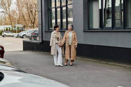 Una pareja de lesbianas maduras y hermosas caminando juntas en una calle de la ciudad.